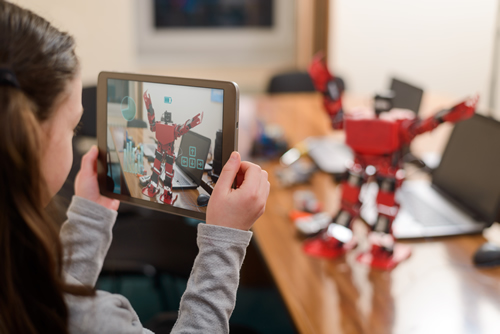 An elementary school girl taking a photo on her iPad of her robot