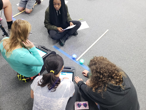 girls on a blacktop completing a challenge with their Spheros