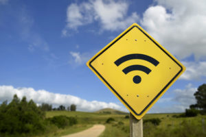 A wi-fi sign on a country road illustrates the idea that internet access for rural students is challenging.