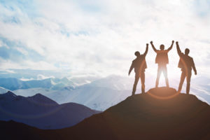 silhouette of three people on a mountain