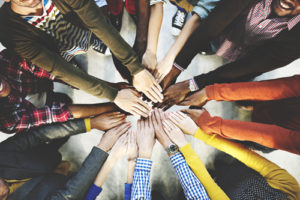 A group of diverse people doing an all hands