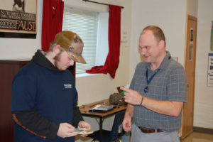 A teacher helps his student with a presentation.