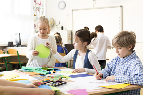 Elementary students doing art projects.