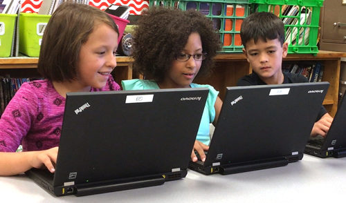 Three students practicing good digital citizenship.