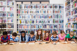 A group of children on their bellies reading books