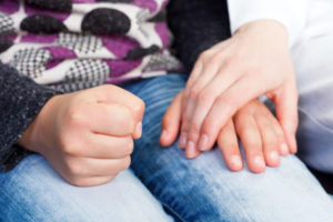 A reassuring hand on a jeans-clad leg