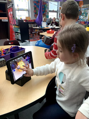 a student using a Merge cube to view AR images