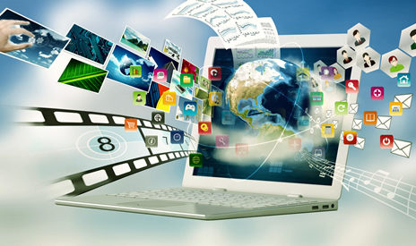 a laptop with videos, images, and all sorts of design tools around it